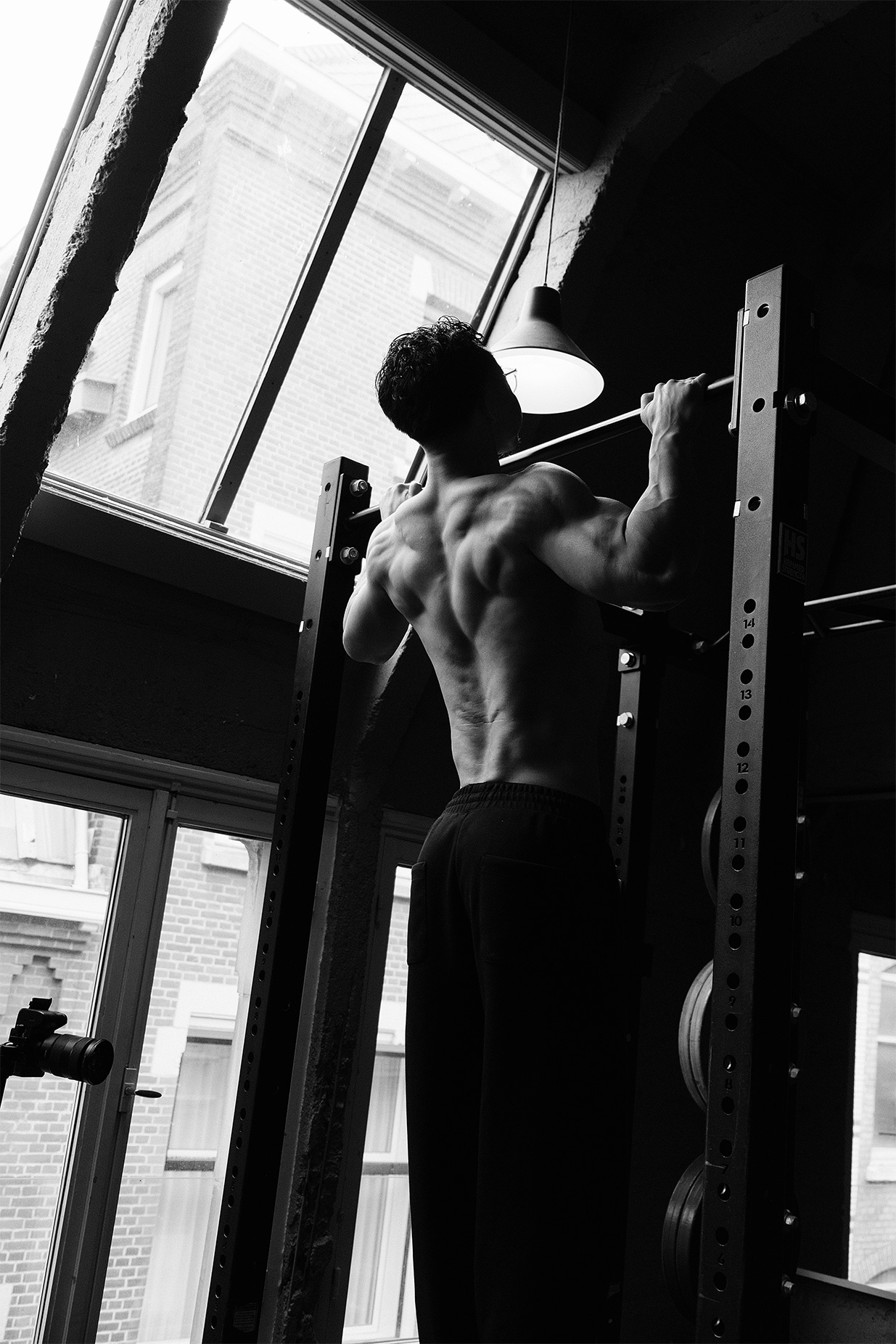 Coach doing pull ups topless.